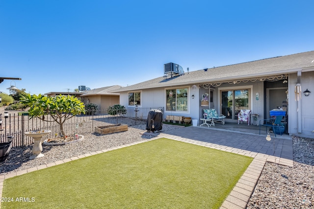 back of property featuring a patio, central air condition unit, and a lawn