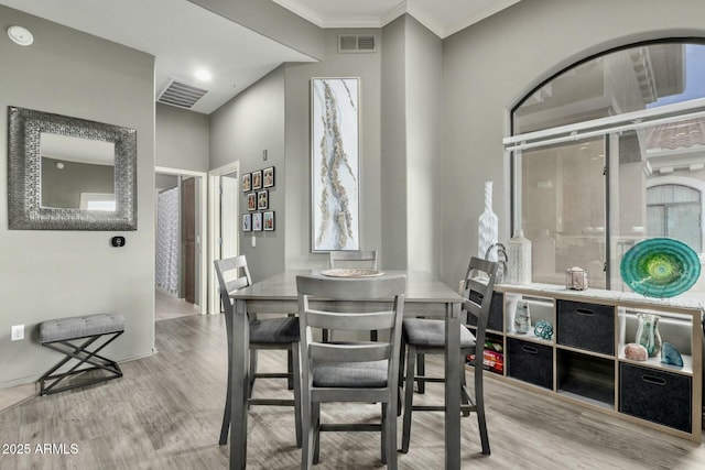 dining area featuring crown molding, visible vents, and wood finished floors