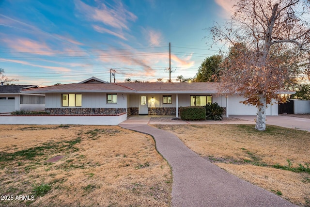 ranch-style home with a garage and a lawn