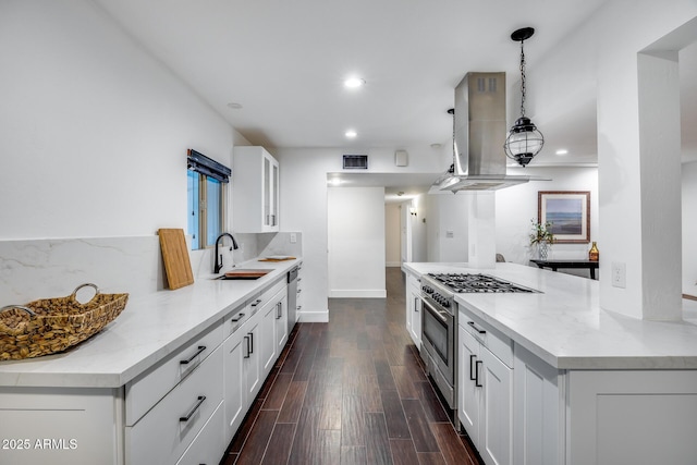 kitchen with white cabinetry, sink, high end stove, and island exhaust hood