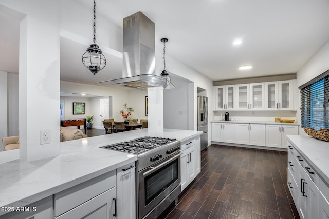 kitchen featuring decorative light fixtures, island range hood, stainless steel appliances, and white cabinets