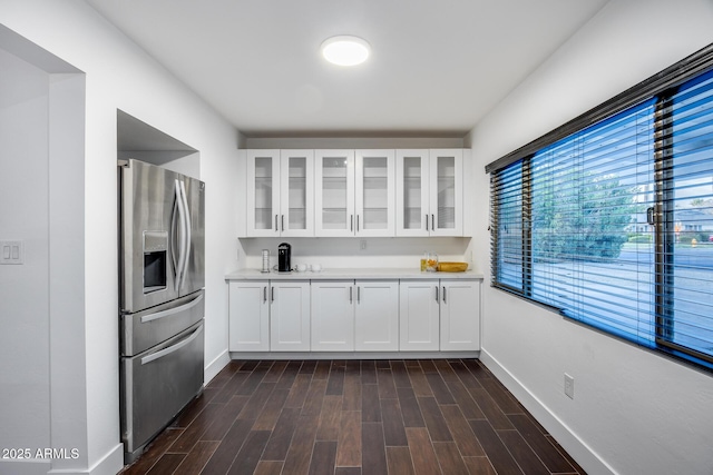 kitchen featuring stainless steel refrigerator with ice dispenser, white cabinetry, and dark wood-type flooring