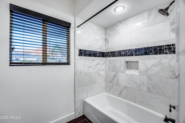 bathroom featuring tiled shower / bath combo and a textured ceiling