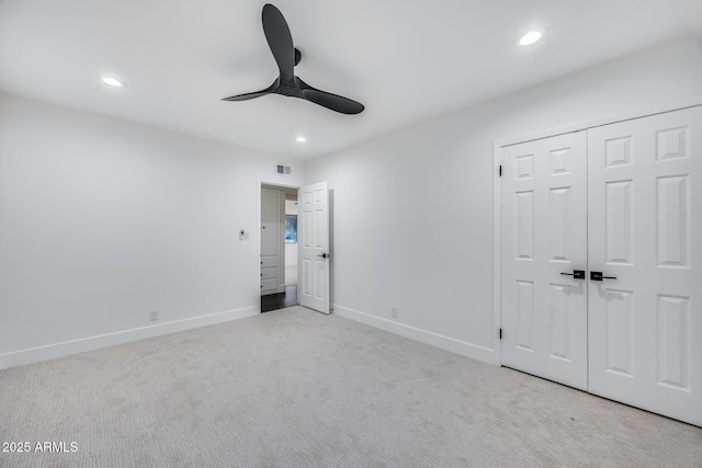 unfurnished bedroom with ceiling fan, a closet, and light carpet