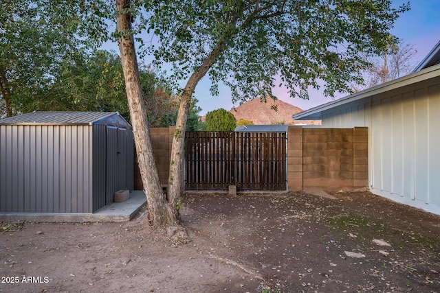 gate at dusk featuring a storage unit