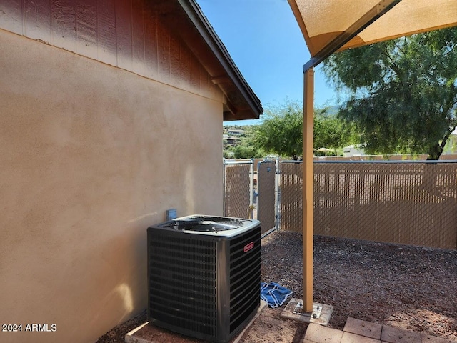 exterior space with central AC, fence, and a gate