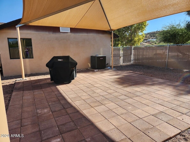 view of patio with fence, cooling unit, and a gate