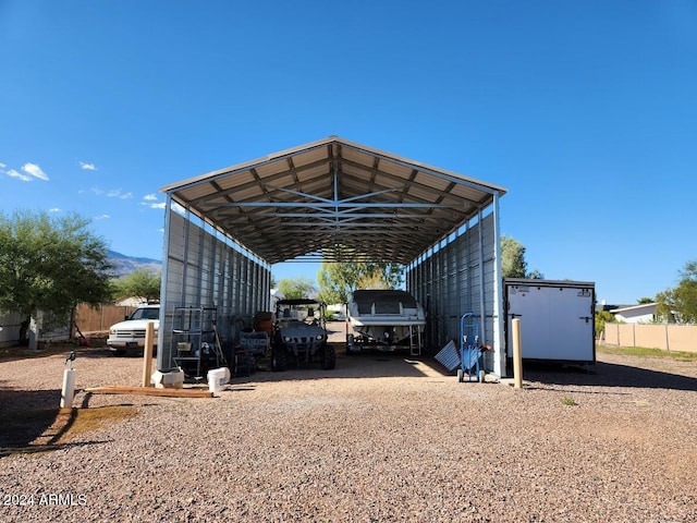 view of parking / parking lot featuring a carport and dirt driveway