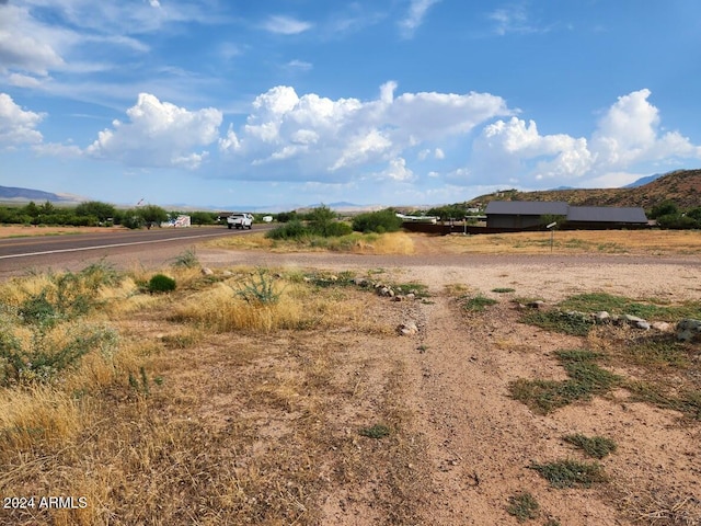 view of yard with a rural view and a mountain view