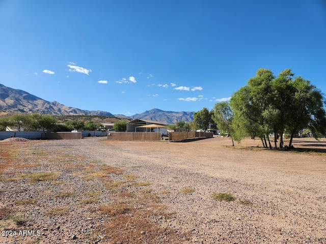 view of yard featuring fence, a mountain view, and a rural view