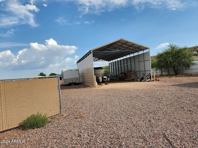 view of outdoor structure with driveway and a detached carport