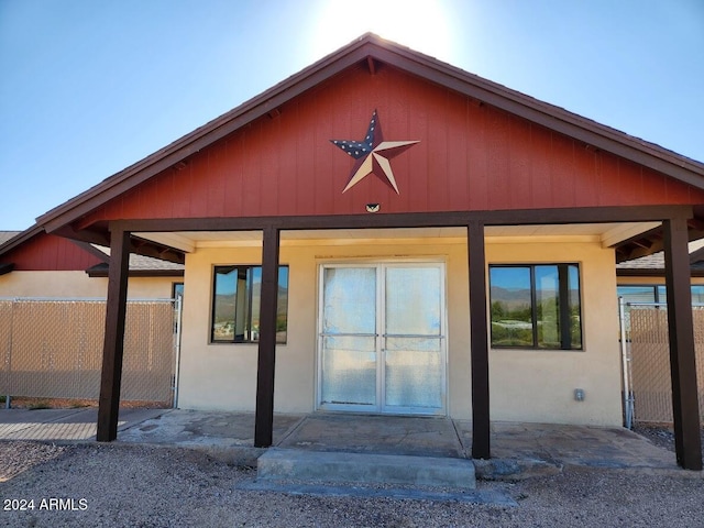 exterior space featuring stucco siding, fence, and a gate