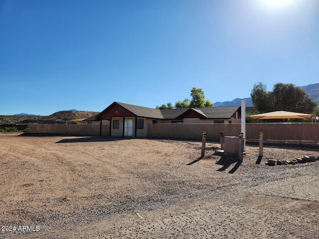 view of front of home with a mountain view and fence