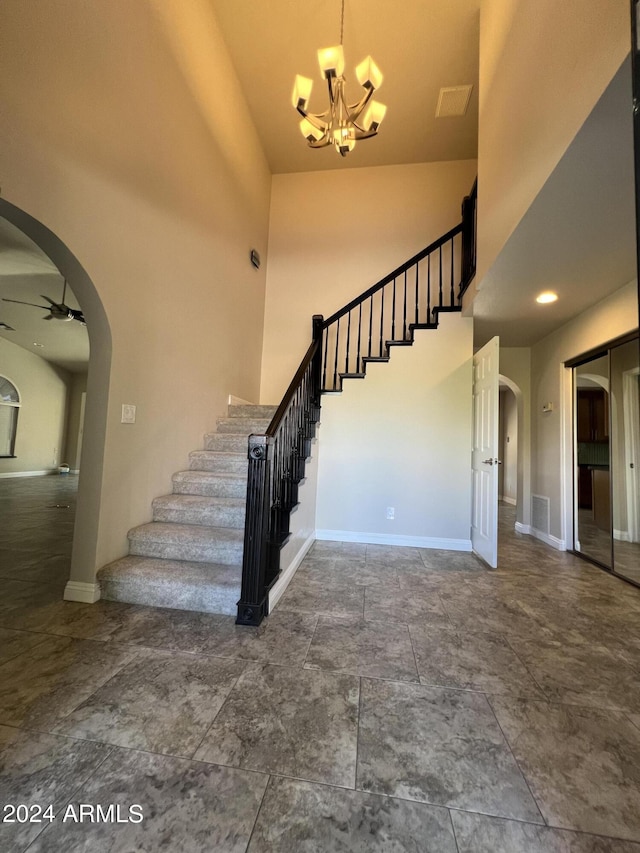 15230 N Blackbird Dr, Fountain Hills, AZ 85268 - stairs with arched walkways, a chandelier, a ceiling fan, a high ceiling, and baseboards