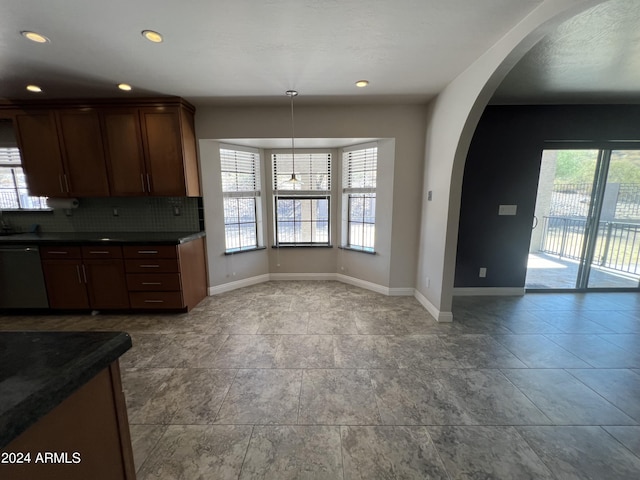 15230 N Blackbird Dr, Fountain Hills, AZ 85268 - kitchen featuring dishwasher, baseboards, dark countertops, arched walkways, and tasteful backsplash