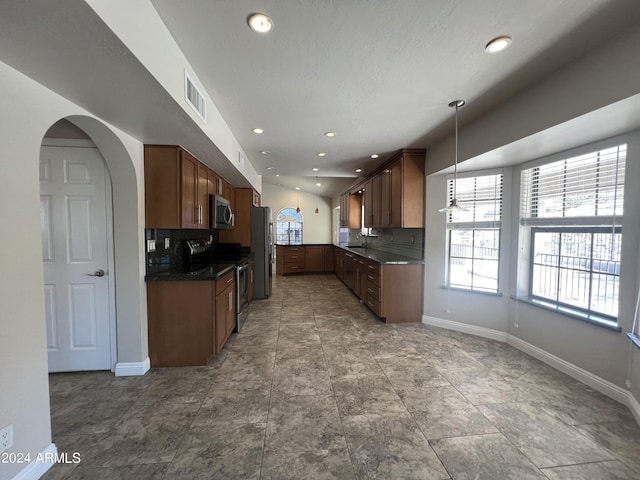 15230 N Blackbird Dr, Fountain Hills, AZ 85268 - kitchen with appliances with stainless steel finishes, dark countertops, baseboards, arched walkways, and decorative backsplash
