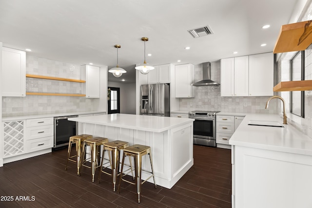 8007 E Del Tesoro Dr, Scottsdale, AZ 85258 - kitchen with appliances with stainless steel finishes, wall chimney range hood, open shelves, a kitchen island, and backsplash