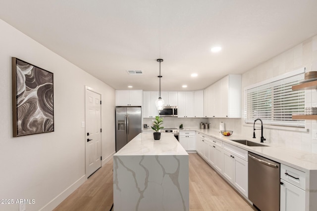 2348 E Diamond Ave, Mesa, AZ 85204 - kitchen featuring stainless steel appliances, a sink, light wood finished floors, white cabinetry, and a kitchen island