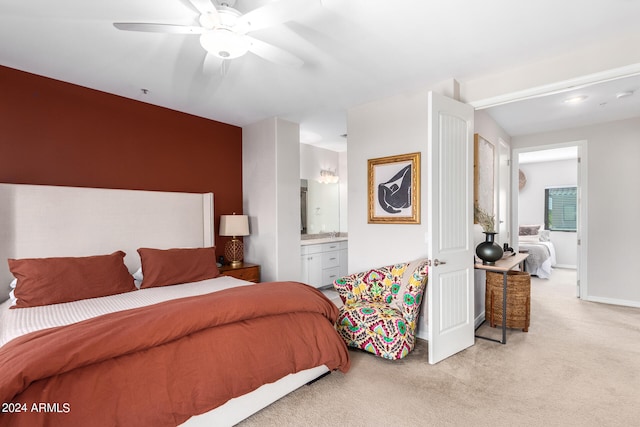 carpeted bedroom with ensuite bath and ceiling fan