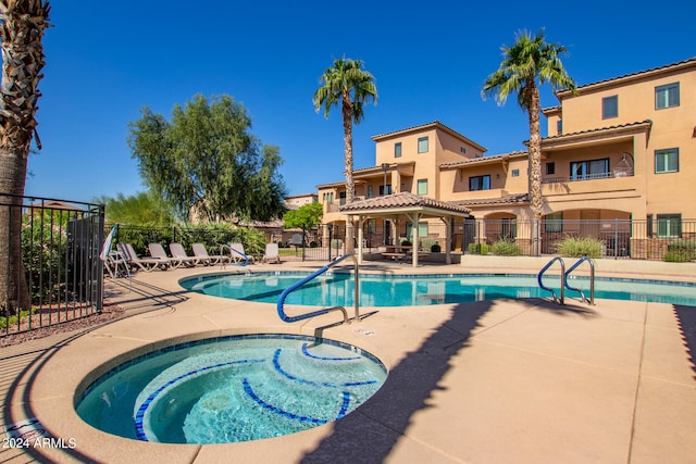 view of pool with a hot tub and a patio