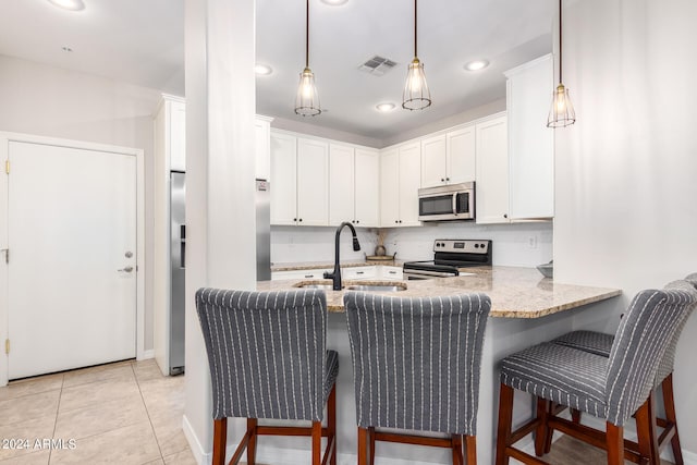 kitchen with white cabinetry, appliances with stainless steel finishes, sink, and kitchen peninsula