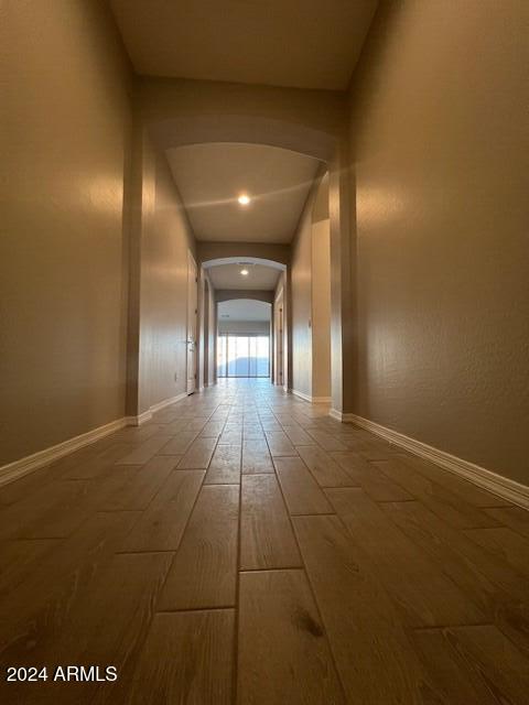 hall featuring wood-type flooring and vaulted ceiling