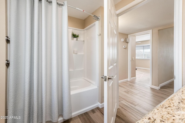 bathroom featuring hardwood / wood-style flooring and shower / bath combination with curtain