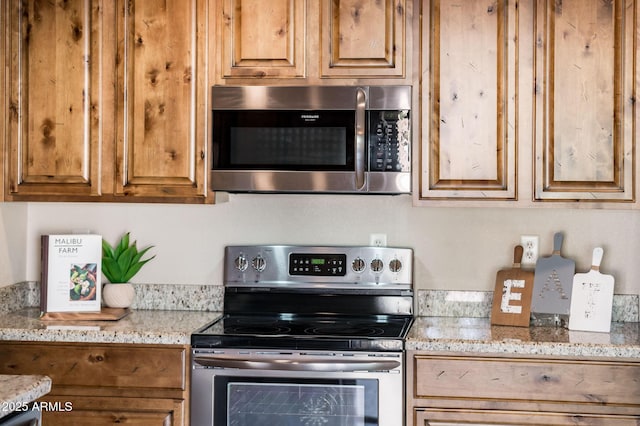 kitchen featuring light stone counters and stainless steel appliances