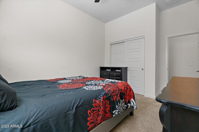 bedroom with a closet, light colored carpet, ceiling fan, and lofted ceiling