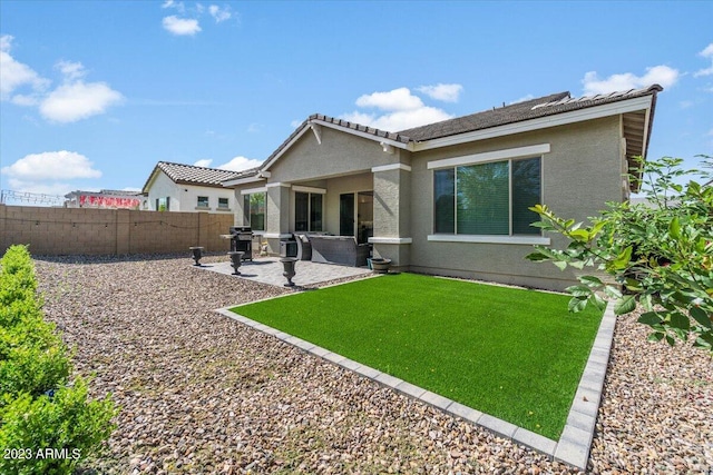 rear view of house with a yard and a patio area