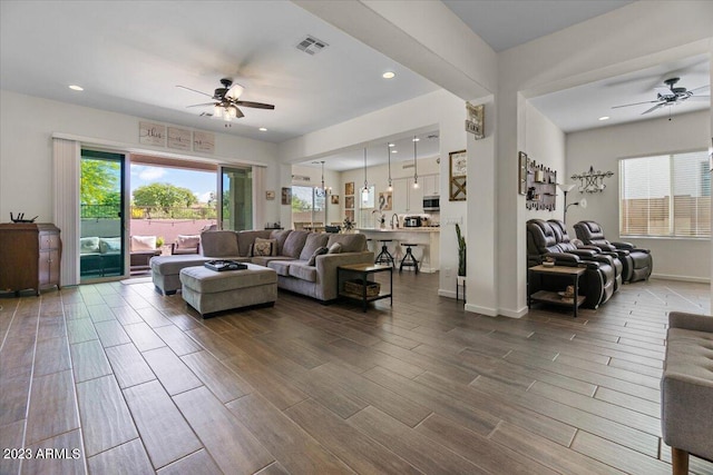 living room featuring ceiling fan and dark wood-type flooring