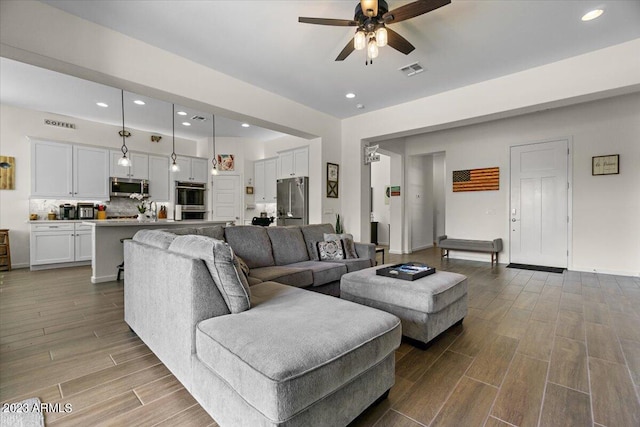 living room featuring ceiling fan and light hardwood / wood-style flooring