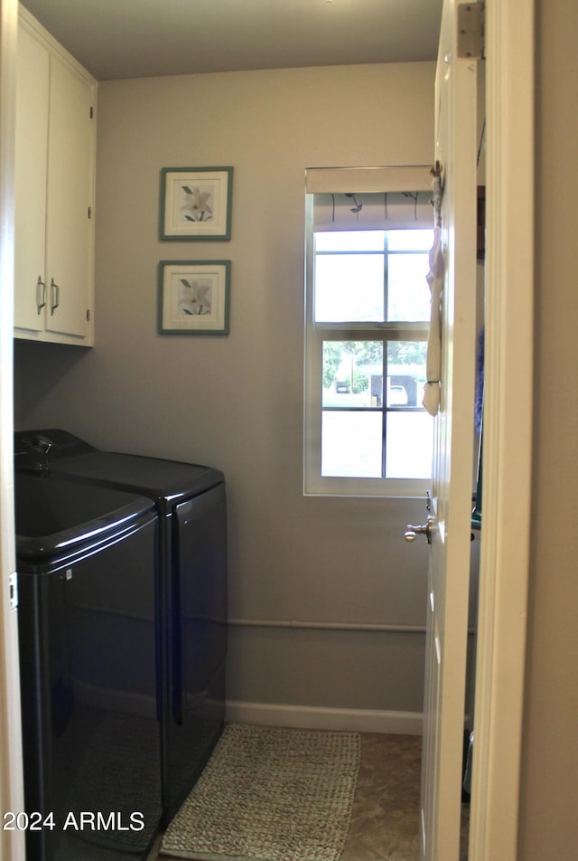 laundry room with cabinet space, baseboards, and independent washer and dryer