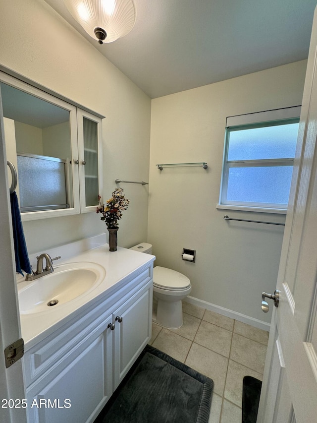 bathroom featuring toilet, baseboards, vanity, and tile patterned floors