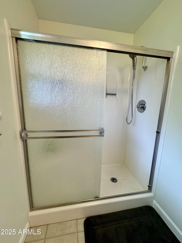 full bath with baseboards, a stall shower, and tile patterned floors