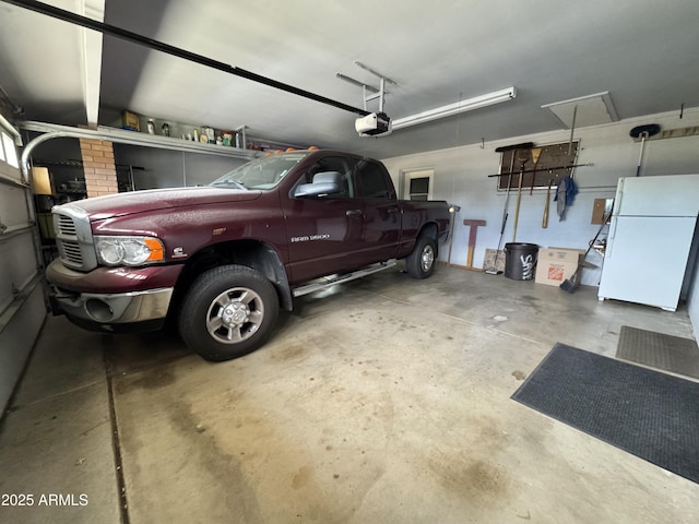 garage with a garage door opener and freestanding refrigerator