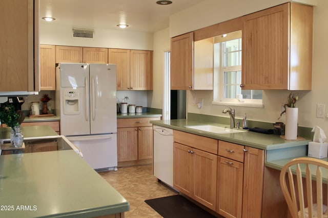 kitchen featuring light countertops, white appliances, a sink, and visible vents