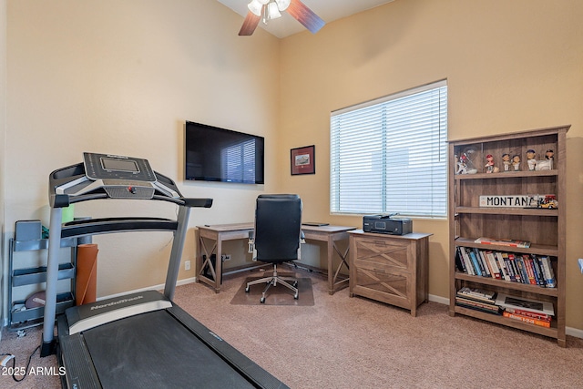 carpeted home office featuring baseboards and a ceiling fan