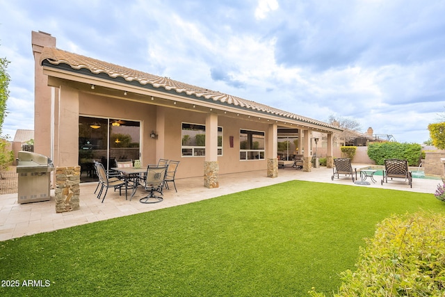 back of house with a patio, a yard, and stucco siding