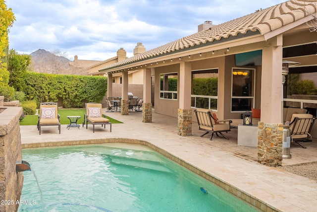 view of swimming pool with outdoor dining area, a patio area, and a mountain view