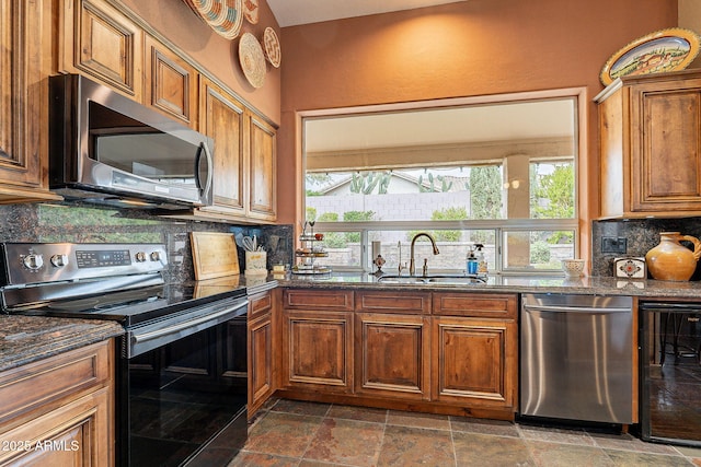 kitchen featuring brown cabinetry, beverage cooler, a sink, stainless steel appliances, and backsplash