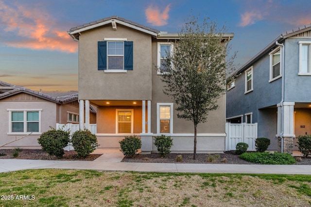 view of front of home with fence and stucco siding