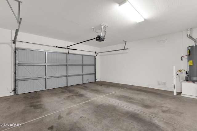 garage with water heater, visible vents, and a garage door opener