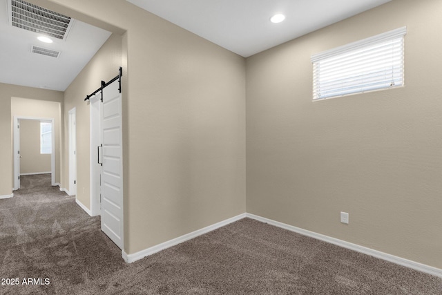 interior space with carpet floors, a barn door, and visible vents