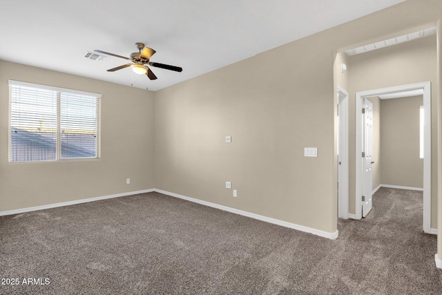 carpeted spare room featuring baseboards, visible vents, and ceiling fan