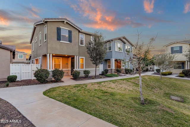 view of front of property with a front lawn, fence, and stucco siding