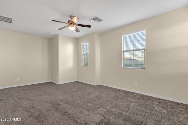 unfurnished room with carpet floors, visible vents, and a healthy amount of sunlight