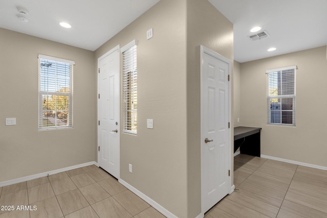 hallway with recessed lighting, visible vents, baseboards, and light tile patterned floors