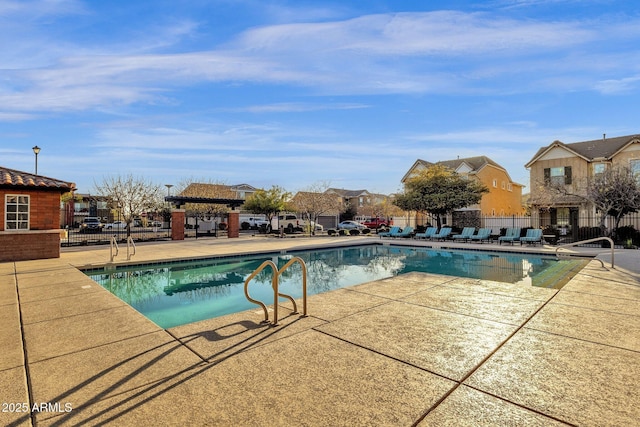 pool with a patio and fence