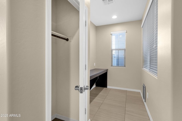 interior space featuring baseboards, visible vents, and tile patterned flooring